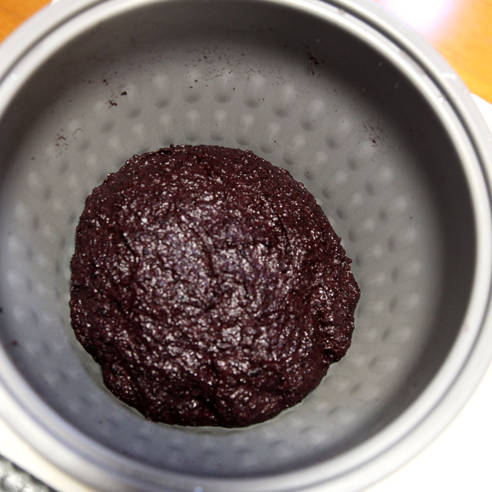 mochi maker will pound the glutinous wild black rice into mochi